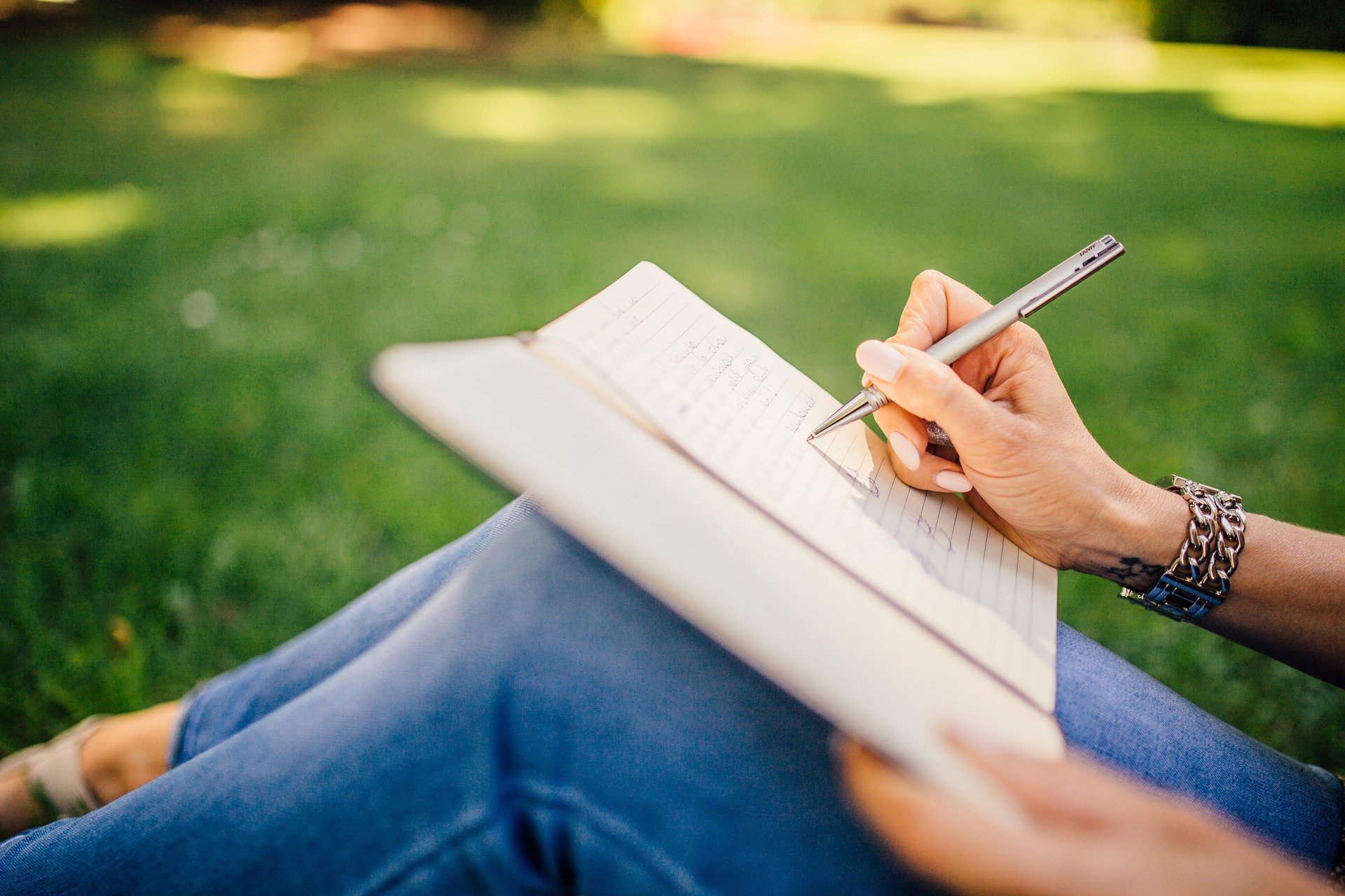 Woman completing a writing prompt outside for Kindle book inspiration.